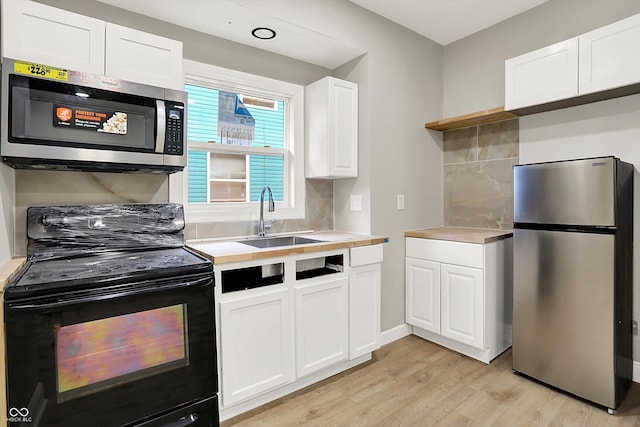 1033 N Dearborn St, Indianapolis, IN 46201 - kitchen featuring appliances with stainless steel finishes, a sink, light wood-style flooring, light countertops, and open shelves