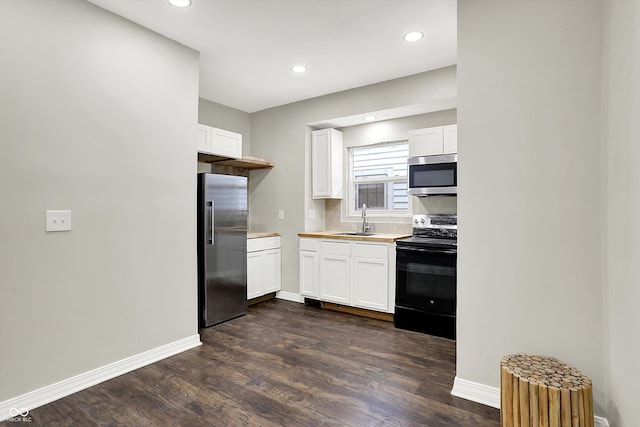 1033 N Dearborn St, Indianapolis, IN 46201 - kitchen with stainless steel appliances, a sink, white cabinets, dark wood-style flooring, and light countertops