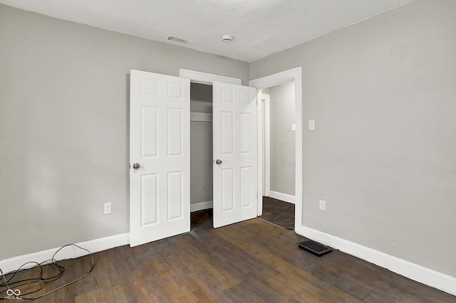 1033 N Dearborn St, Indianapolis, IN 46201 - unfurnished bedroom featuring baseboards, dark wood-type flooring, and a closet