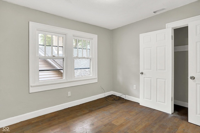 1033 N Dearborn St, Indianapolis, IN 46201 - unfurnished bedroom with baseboards and dark wood-style flooring