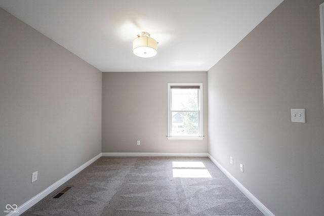 empty room featuring carpet floors and baseboards