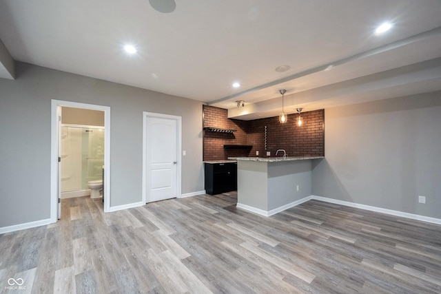 kitchen featuring a peninsula, wood finished floors, baseboards, pendant lighting, and recessed lighting