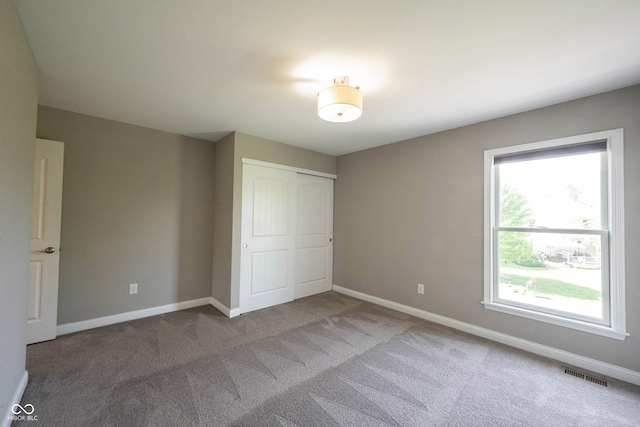 unfurnished bedroom featuring carpet flooring, a closet, and baseboards