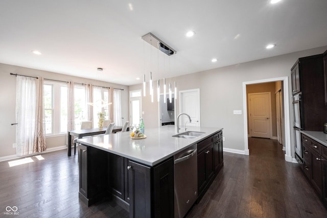 kitchen with appliances with stainless steel finishes, a sink, light countertops, baseboards, and recessed lighting