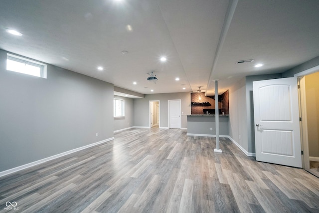 unfurnished living room featuring wood finished floors, recessed lighting, and baseboards