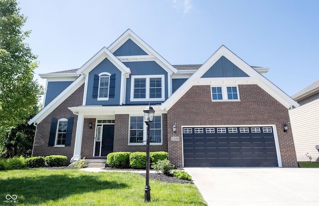 view of front of home with concrete driveway, brick siding, a front yard, and an attached garage