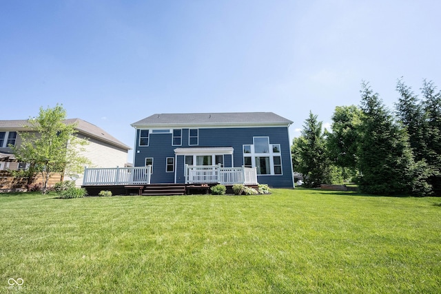 back of house featuring a lawn and a wooden deck