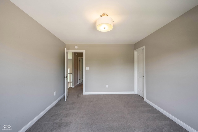 unfurnished room featuring carpet and baseboards