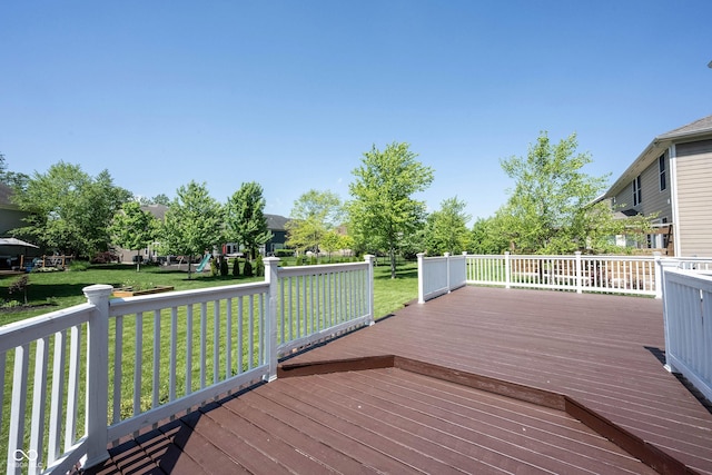 wooden deck with a playground and a lawn