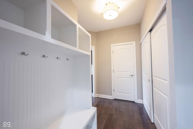 mudroom with dark wood-style floors and baseboards