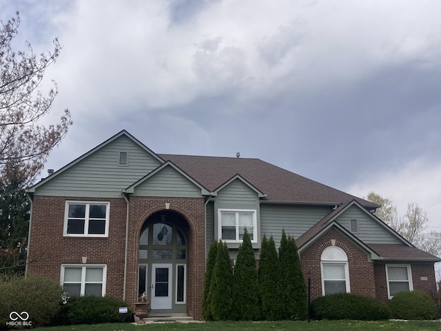 11458 Sutton Place Dr W, Carmel, IN 46032 - traditional-style house featuring brick siding, a front yard, and roof with shingles