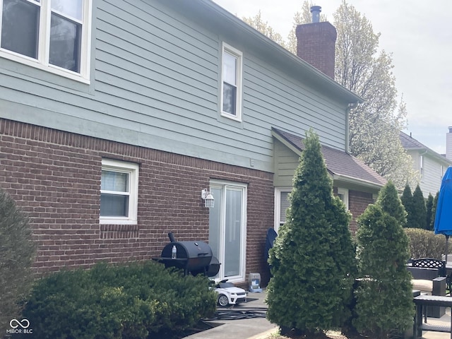 11458 Sutton Place Dr W, Carmel, IN 46032 - rear view of property featuring brick siding and a chimney