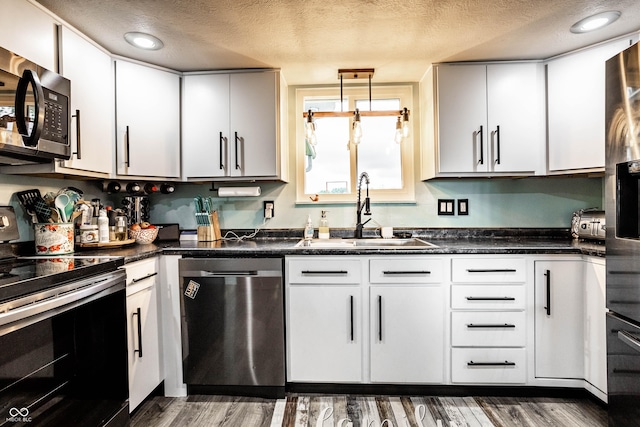 2965 E 1100 N, Pendleton, IN 46064 - kitchen featuring appliances with stainless steel finishes, a sink, a textured ceiling, wood finished floors, and dark countertops