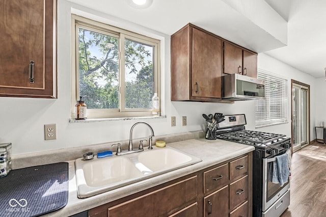 5427 Heights Ave, Indianapolis, IN 46237 - kitchen with stainless steel appliances, a sink, light countertops, wood finished floors, and dark brown cabinets
