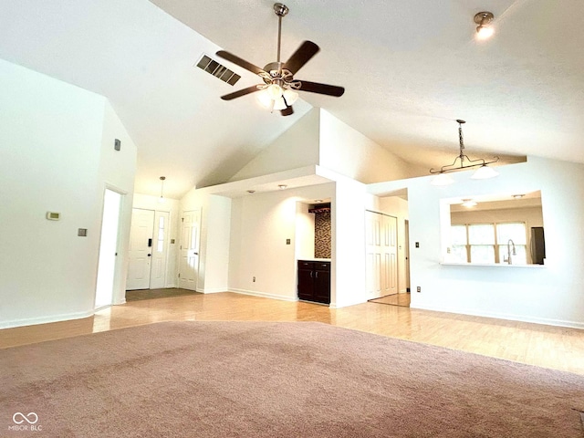 6143 Roberts Pl, Indianapolis, IN 46220 - unfurnished living room with light colored carpet, a ceiling fan, high vaulted ceiling, baseboards, and a sink