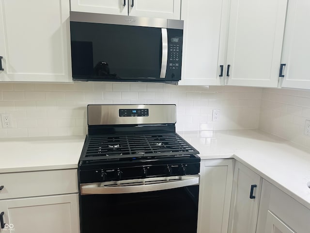 1718 Thaddeus St, Indianapolis, IN 46203 - kitchen featuring stainless steel appliances, white cabinets, light countertops, and decorative backsplash