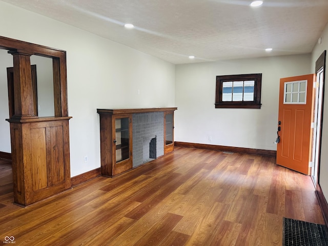 1718 Thaddeus St, Indianapolis, IN 46203 - unfurnished living room with wood finished floors, baseboards, recessed lighting, and a fireplace