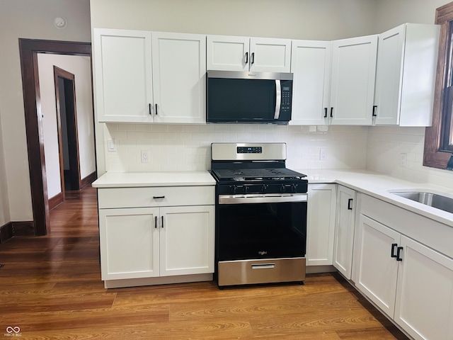 1718 Thaddeus St, Indianapolis, IN 46203 - kitchen featuring stainless steel appliances, white cabinets, light countertops, and backsplash