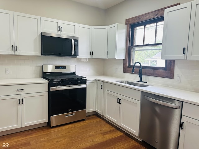 1718 Thaddeus St, Indianapolis, IN 46203 - kitchen with appliances with stainless steel finishes, a sink, white cabinetry, light countertops, and decorative backsplash