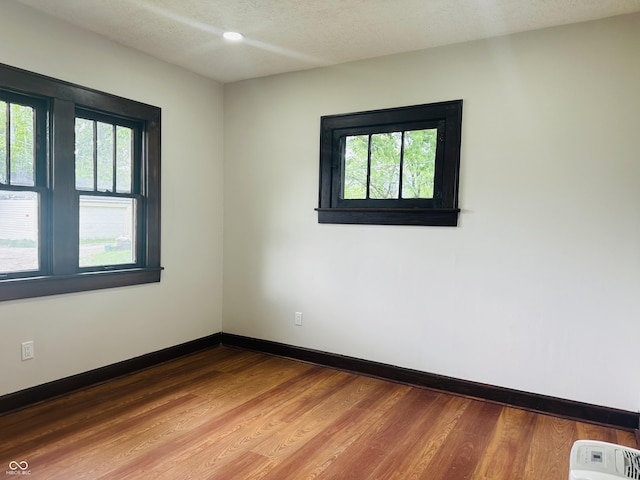 1718 Thaddeus St, Indianapolis, IN 46203 - unfurnished room with wood finished floors, baseboards, and a textured ceiling