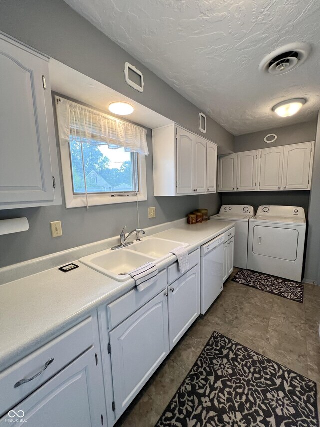 2508 Pamela Ct, Anderson, IN 46012 - kitchen featuring dishwasher, washer and dryer, white cabinetry, a sink, and light countertops