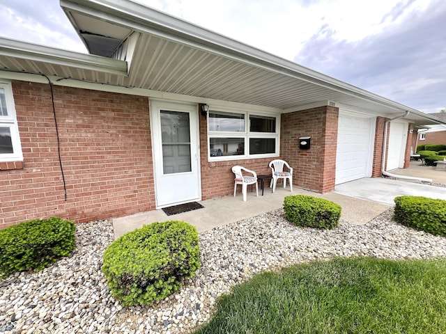 2508 Pamela Ct, Anderson, IN 46012 - view of exterior entry with brick siding, a garage, and covered porch