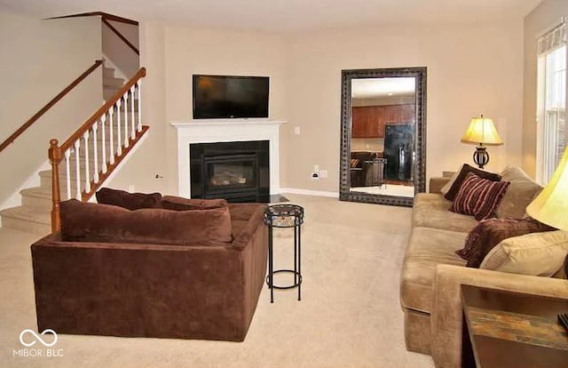 6304 El Paso St, Whitestown, IN 46075 - carpeted living room with stairway, a glass covered fireplace, and baseboards