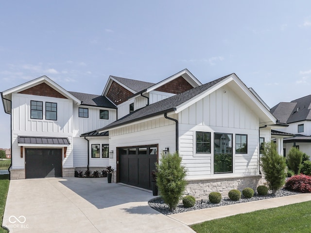 modern farmhouse style home featuring board and batten siding, concrete driveway, stone siding, a shingled roof, and a garage