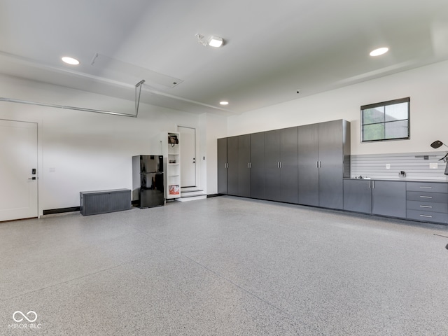garage with recessed lighting and freestanding refrigerator