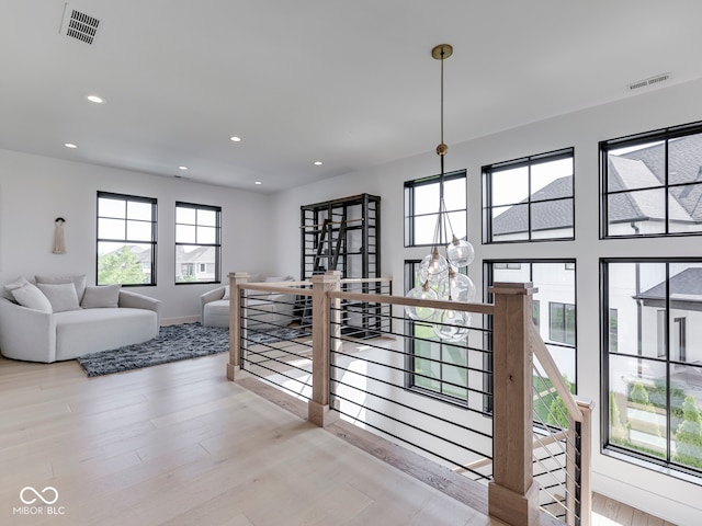 corridor with wood finished floors, an upstairs landing, recessed lighting, and baseboards