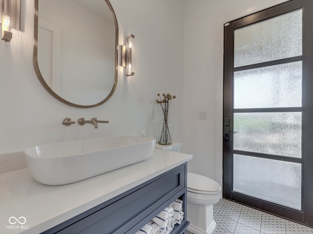bathroom with vanity, toilet, and tile patterned floors