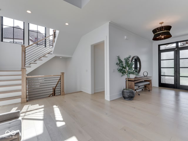 living area with french doors, wood finished floors, baseboards, recessed lighting, and stairway