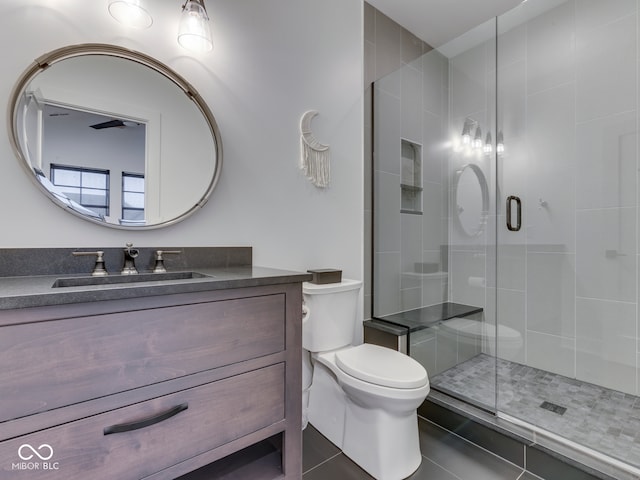 full bathroom featuring toilet, tile patterned flooring, vanity, and a stall shower