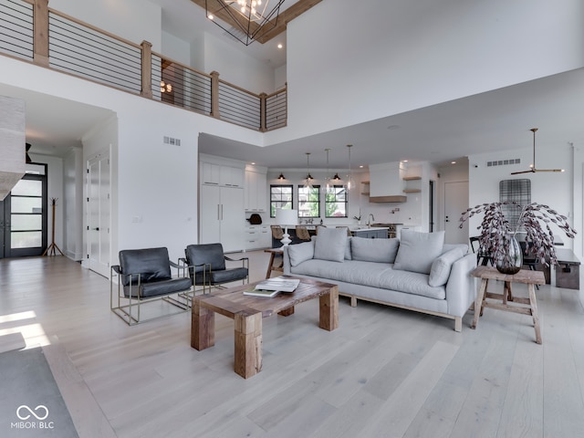 living room with light wood finished floors, a high ceiling, and recessed lighting