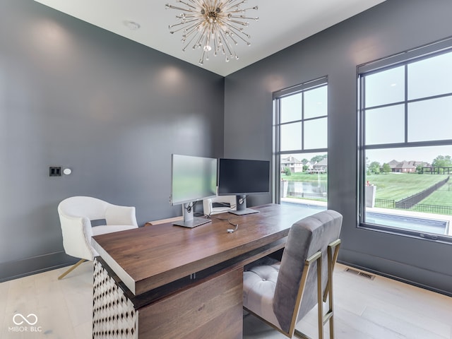 office area featuring healthy amount of natural light, a chandelier, and light wood-style floors
