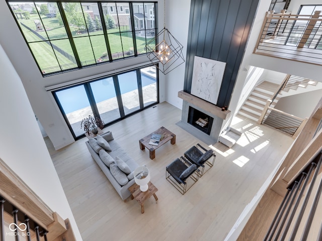 living room featuring a towering ceiling, wood finished floors, and a chandelier