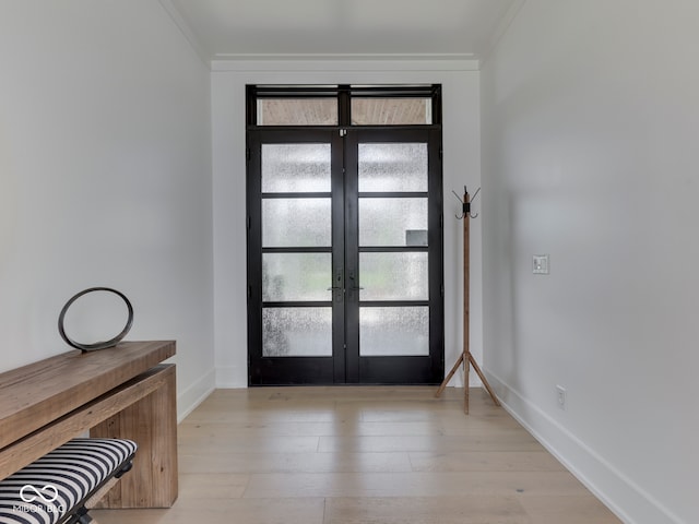 entryway with french doors, crown molding, light wood finished floors, and baseboards