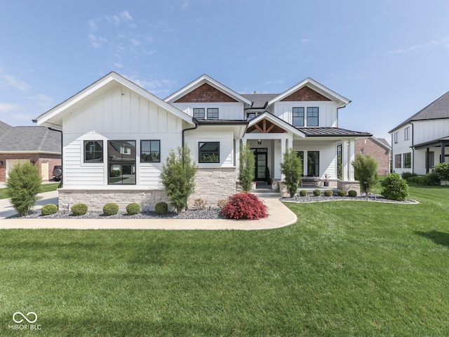 modern inspired farmhouse with board and batten siding, stone siding, a front lawn, and a standing seam roof