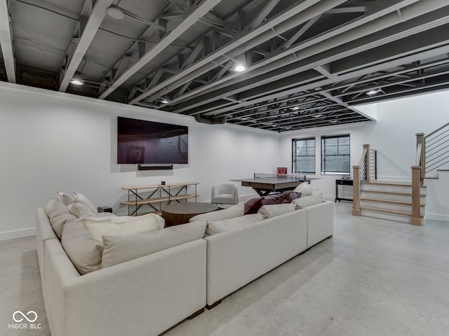 living room with concrete floors, stairway, and baseboards
