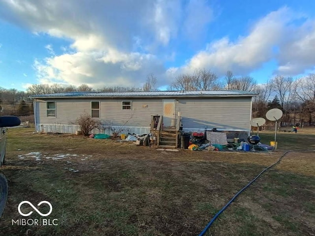 back of house featuring metal roof and entry steps