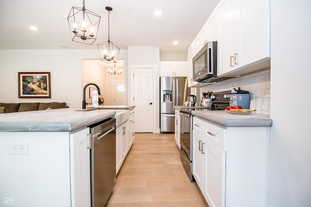 2686 Lafayette Ave, Columbus, IN 47201 - kitchen featuring stainless steel appliances, a sink, a chandelier, light wood finished floors, and light countertops