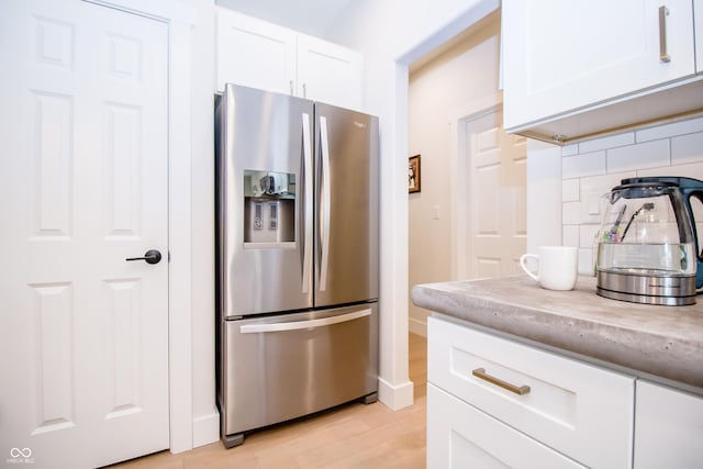 2686 Lafayette Ave, Columbus, IN 47201 - kitchen featuring stainless steel fridge with ice dispenser, tasteful backsplash, white cabinets, and light wood-type flooring