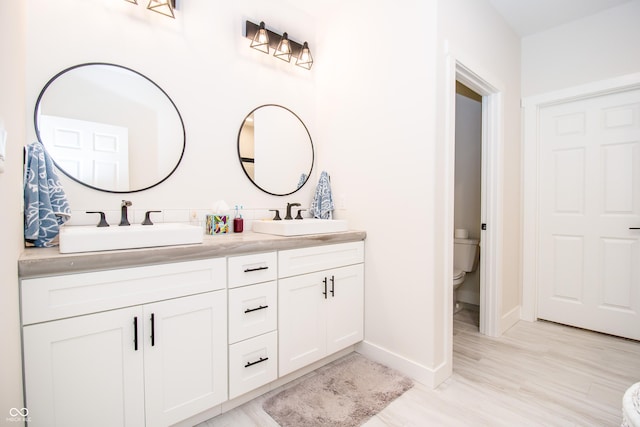 2686 Lafayette Ave, Columbus, IN 47201 - bathroom featuring baseboards, double vanity, and toilet