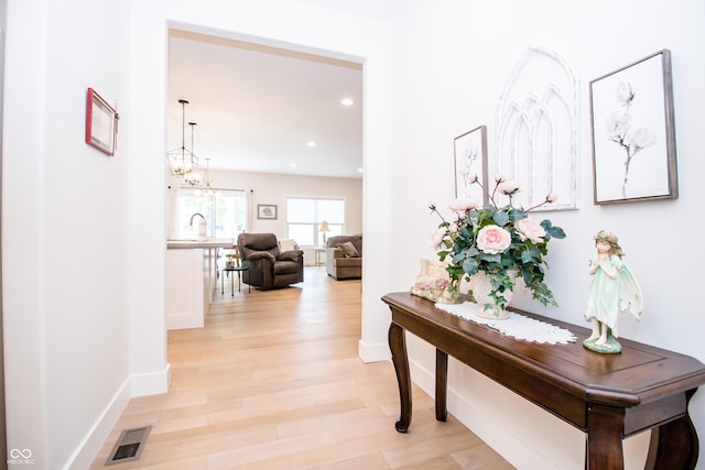 2686 Lafayette Ave, Columbus, IN 47201 - hall featuring light wood-style flooring, recessed lighting, baseboards, a sink, and a chandelier