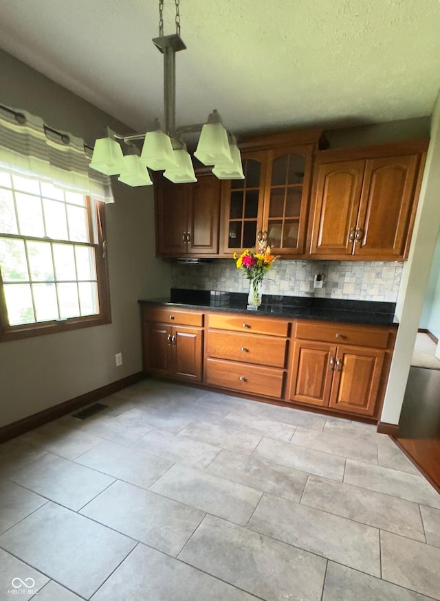 3559 S County Road 475 E, Plainfield, IN 46168 - kitchen with decorative backsplash, glass insert cabinets, dark countertops, brown cabinets, and a textured ceiling