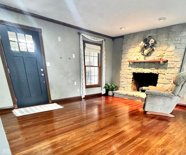 3559 S County Road 475 E, Plainfield, IN 46168 - unfurnished living room with wood finished floors, plenty of natural light, crown molding, a stone fireplace, and baseboards
