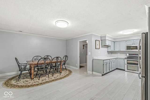 12388 Camberley Ln, Carmel, IN 46033 - dining room featuring light wood finished floors, a textured ceiling, ornamental molding, and baseboards