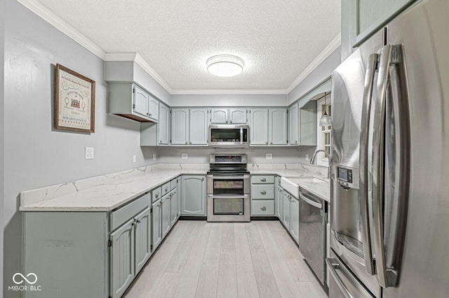 12388 Camberley Ln, Carmel, IN 46033 - kitchen featuring appliances with stainless steel finishes, gray cabinets, a sink, a textured ceiling, and light wood finished floors