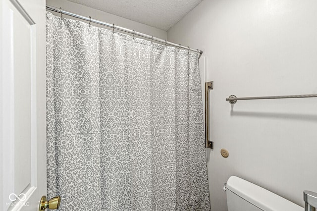 12388 Camberley Ln, Carmel, IN 46033 - bathroom with a textured ceiling, toilet, and a shower with curtain
