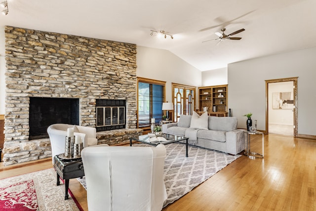 12469 Springmill Rd, Carmel, IN 46032 - living area with a ceiling fan, wood finished floors, a stone fireplace, baseboards, and high vaulted ceiling